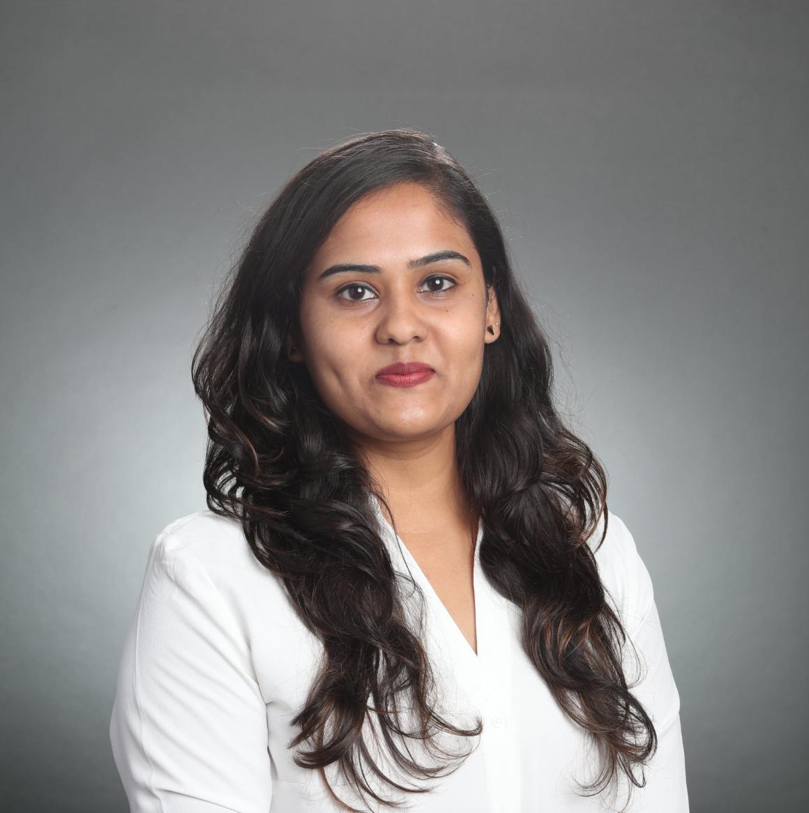 A person in a white shirt against a gray background.