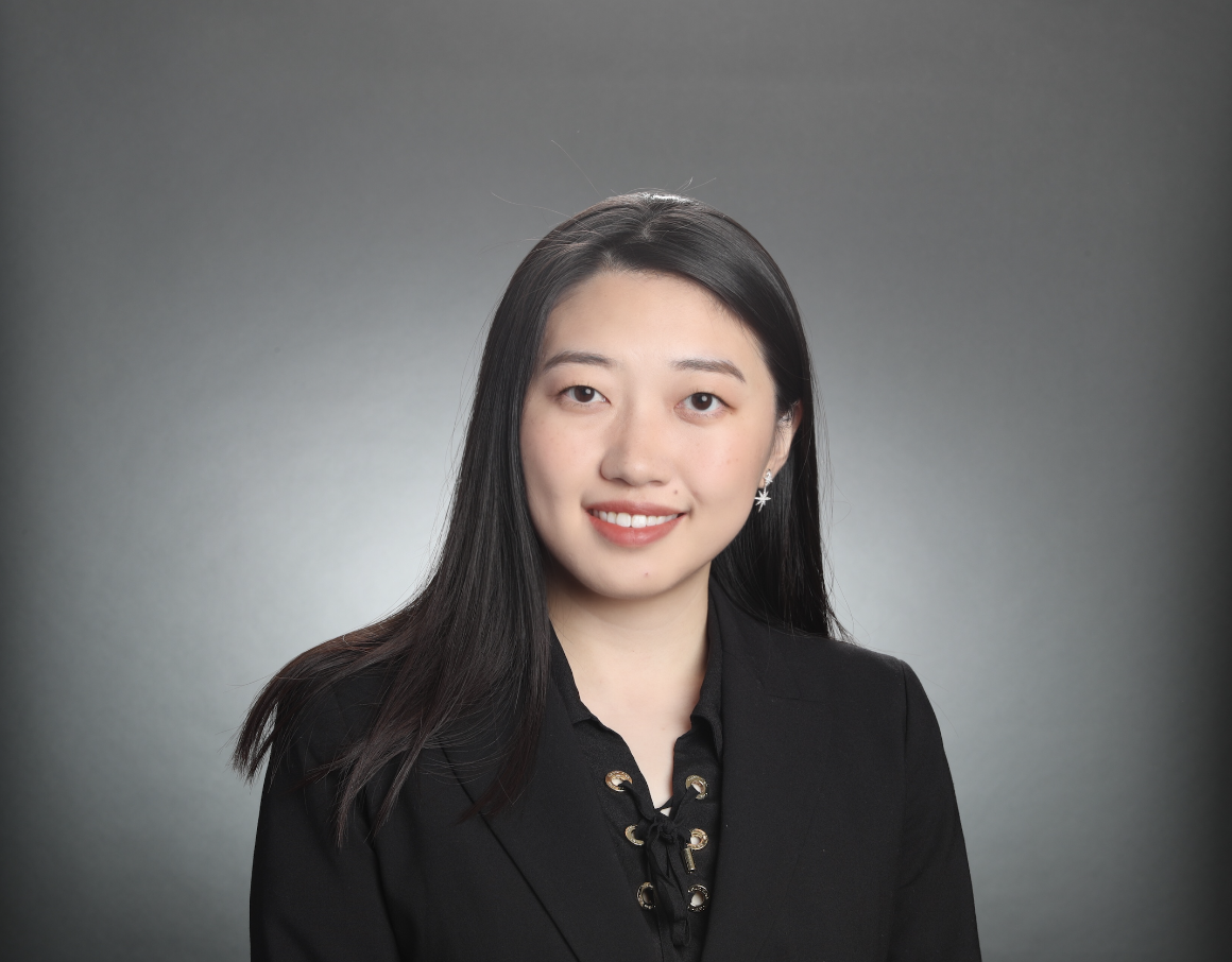 A person in a suit against a gray background.