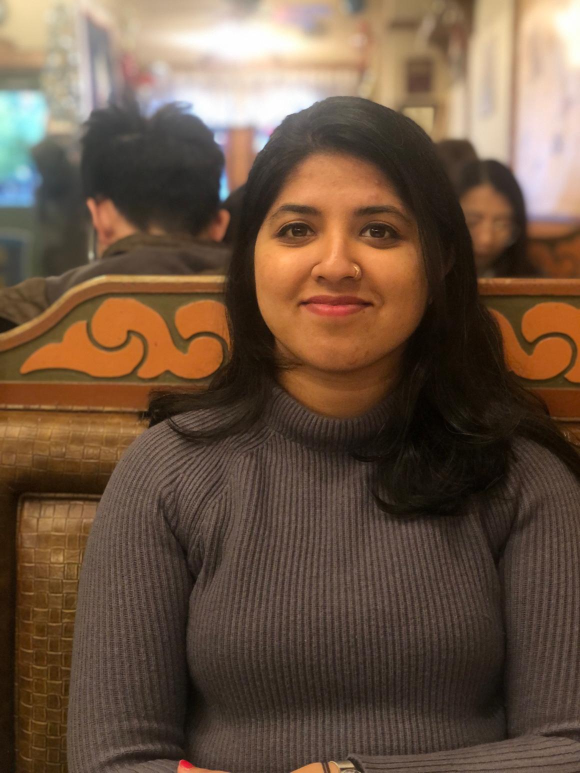 A person sitting and smiling in a restaurant.