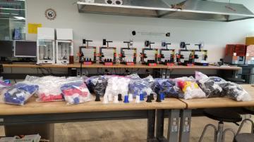 Test tube holders on tables in a laboratory, labeled and ready for delivery.