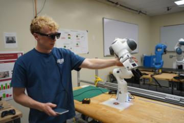 Student using AR glasses while collaborating with a manipulator arm