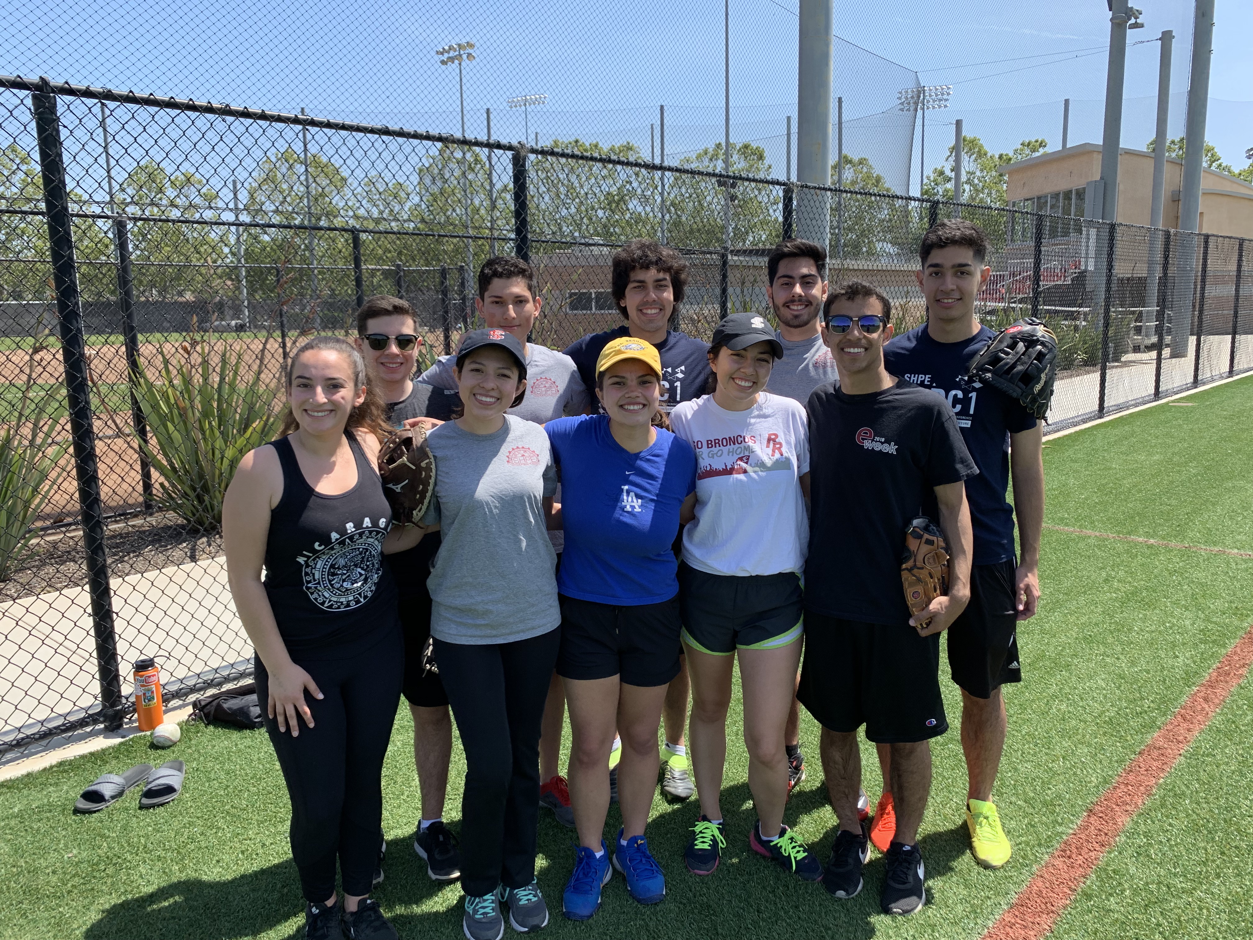 A group of people posing on a softball field.