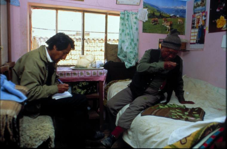 Two people reading in a bedroom with books and posters.