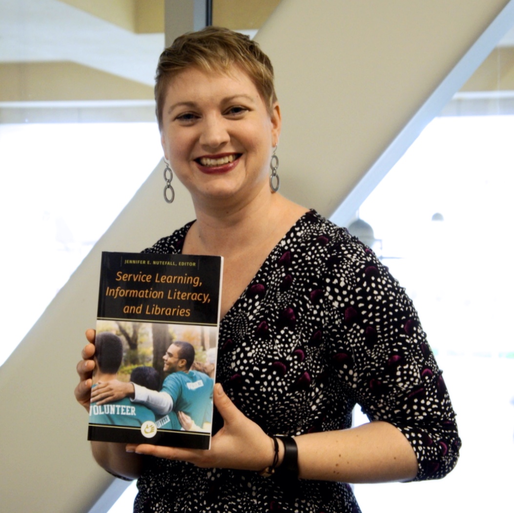 Person holding book and smiling