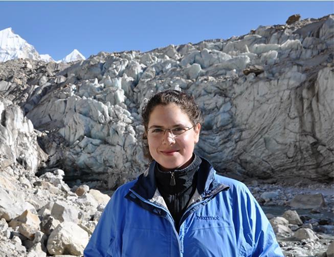 A person in blue jacket in a mountainous area.