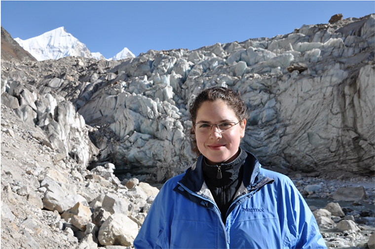 A person in blue jacket in a mountainous area.