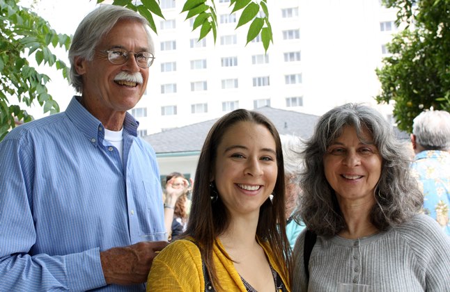 Three people smiling at 'Grad Brunch 2009'. Trees and a building in the background.