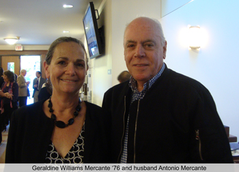 A man and a woman standing together and smiling indoors.