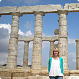 A person standing in front of ancient ruins at Sounion.