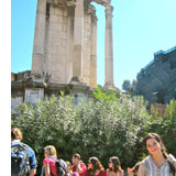 People in front of ruins with columns in Rome on a sunny day.