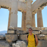 A person standing in front of ancient ruins in Athens.