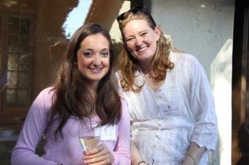 Two people smiling at an event with name tags. 