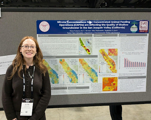 Elyse Kenyon standing her research poster.