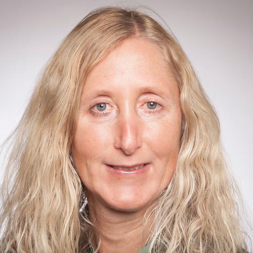 A person with long hair smiling at the camera.