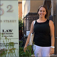 A woman stands next to a 'LAW' office sign.