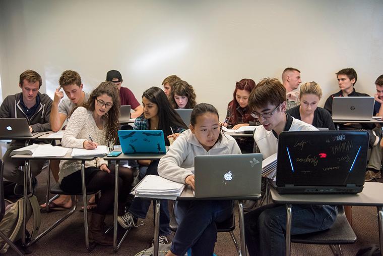 Students in a Computer Science class using laptops in a classroom setting. image link to story