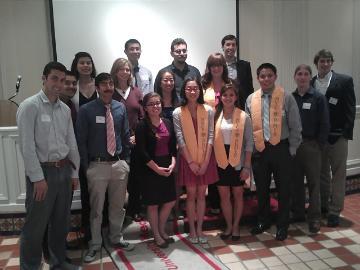 A group of people posing for a photo in front of a screen. image link to story