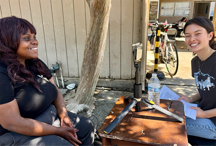 Public Health Capstone student Elsa Kinney conducts a video interview with a guest at Mobile Showers (photo permission granted by interviewee).