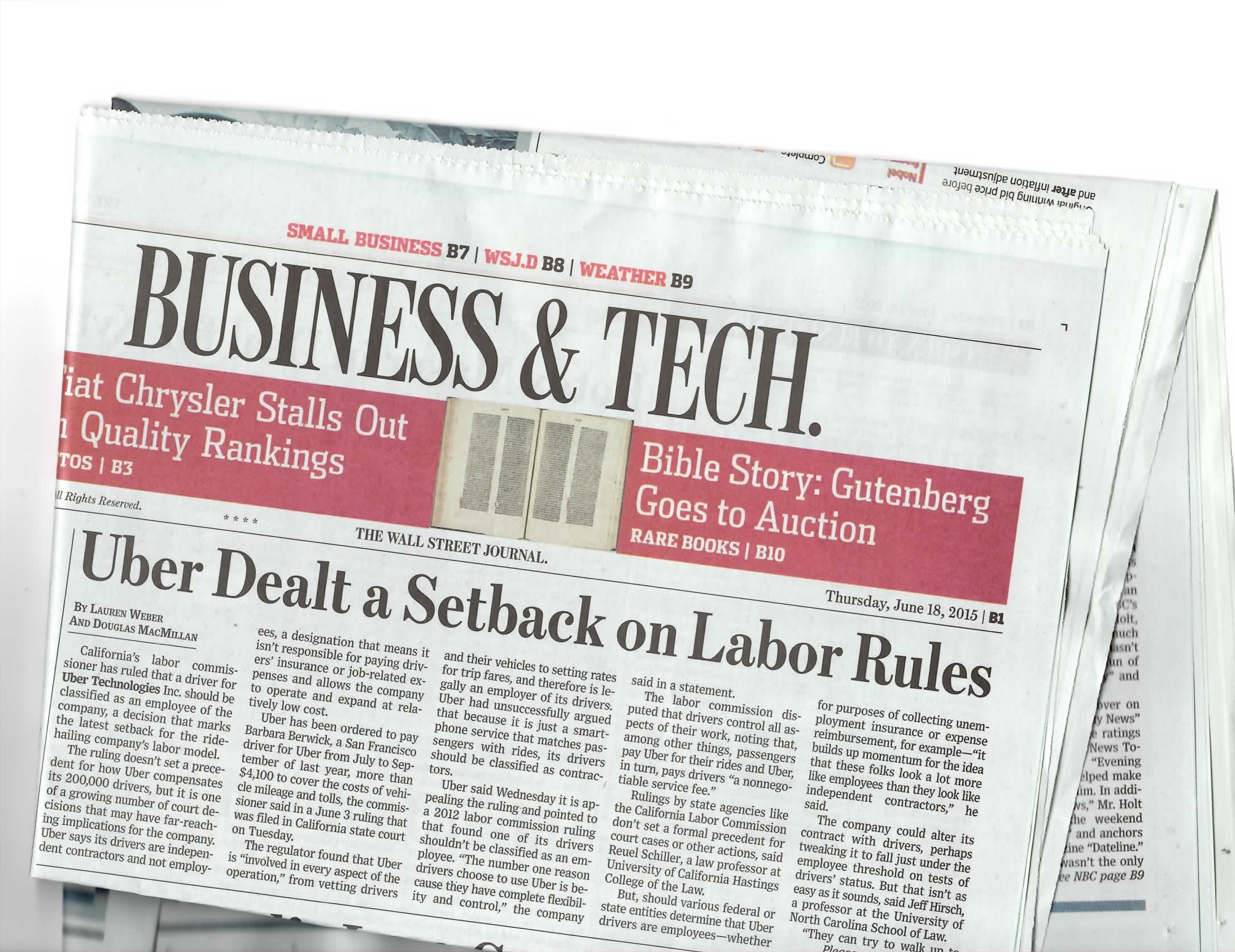 Folded Wall Street Journal newspaper with a headline about Uber's labor rules setback.