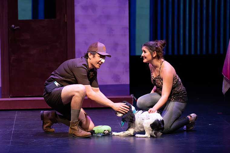 Two actors and a dog performing on stage in 