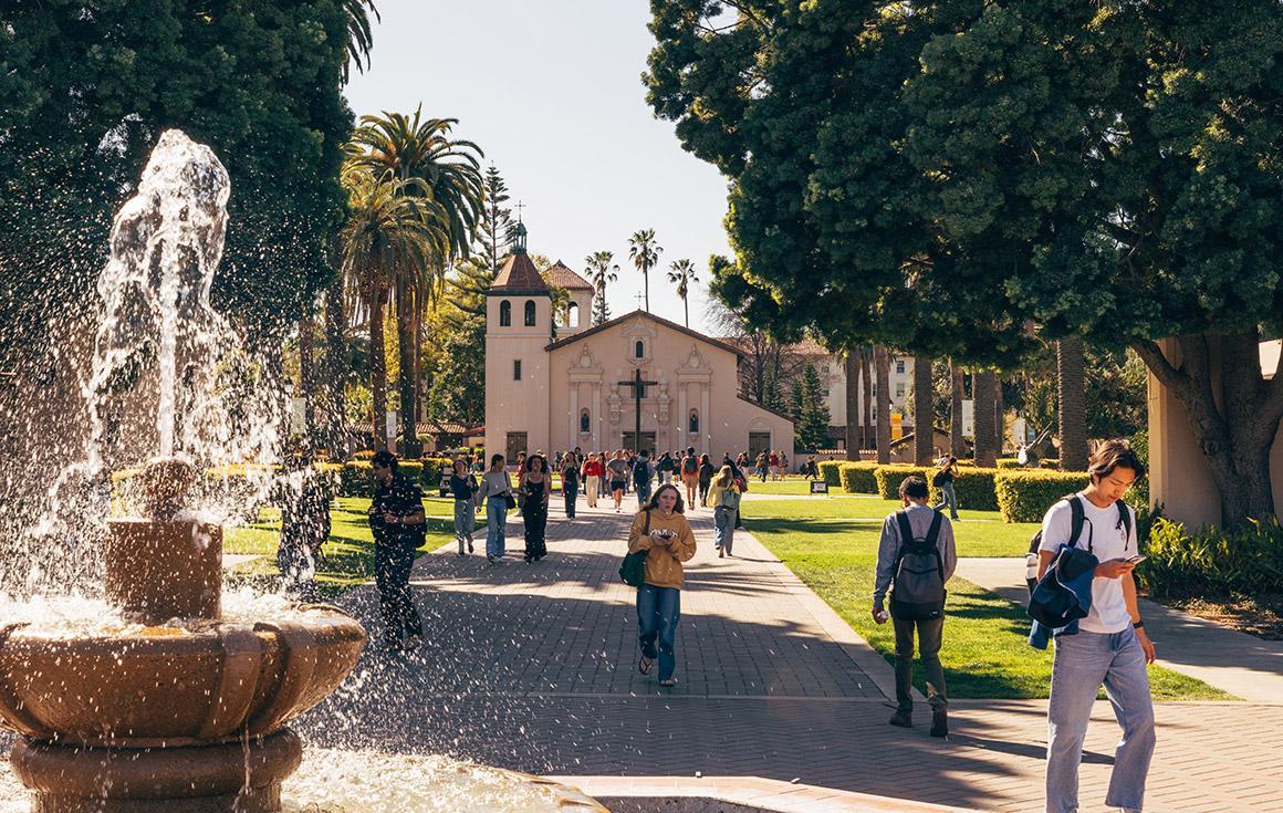 The fountain splashes as students walk around campus. 