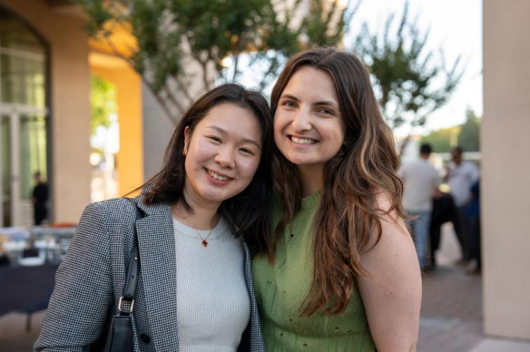 Two people posing at a graduation reception