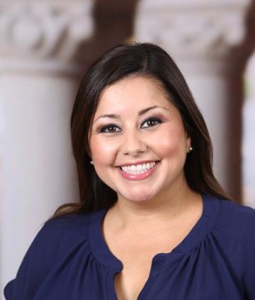 A woman smiling in a dark blue top.