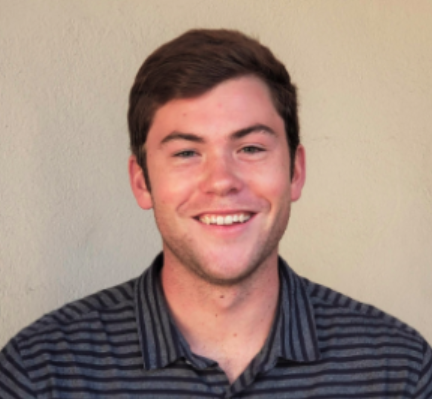 A person smiling against a neutral background.