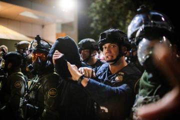 A protester is arrested by police and U.S. Border Patrol officers outside a U.S. Immigration and Customs Enforcement facility in Portland, Ore., Monday, Oct. 6, 2025. (AP Photo/Ethan Swope)