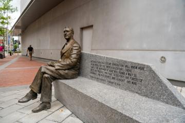 Statue of Franklin Delano Roosevelt sitting on a concrete bench outside the National World War II Museum by Jessica Tan via Unsplash.