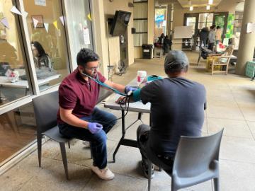 Bilal Arshadullah ’24, Health Equity and Innovation Fellow works with patient at the Opportunity Center Blood Pressure Clinic in Palo Alto, California in May 2025. Photo provided courtesy of Bilal Arshadullah.