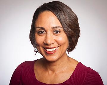 Person smiling in a professional headshot against a plain background.