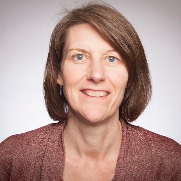 A person smiling, wearing a maroon top.