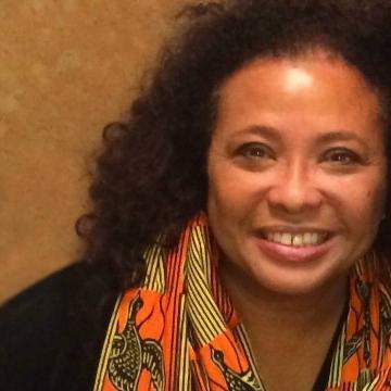 A smiling woman with a colorful scarf.