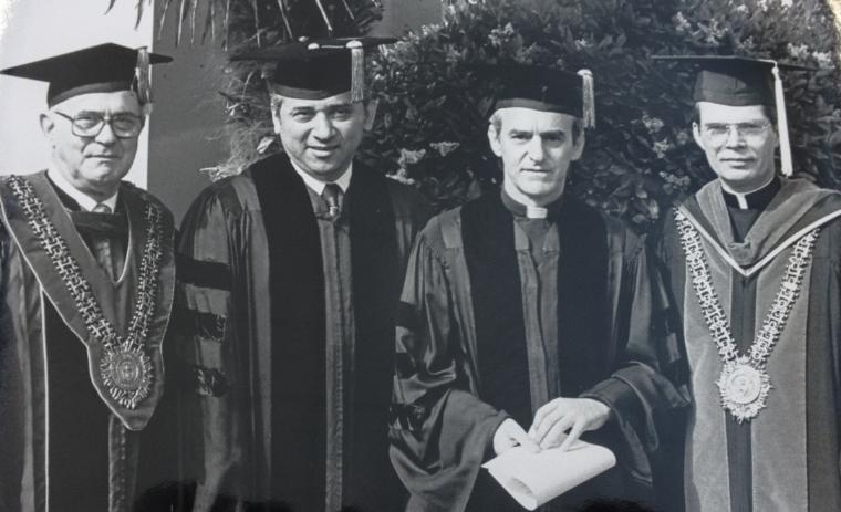 Four individuals in academic regalia at a 1982 commencement ceremony.