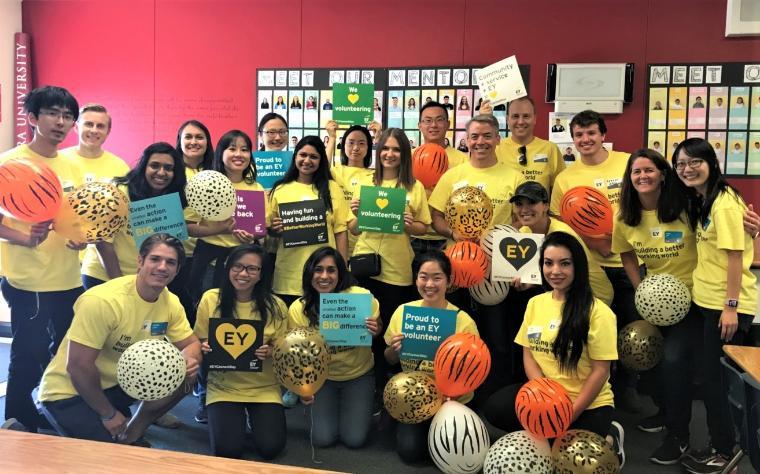 Group of people with balloons at EY Connect Day event, posing for a photo.