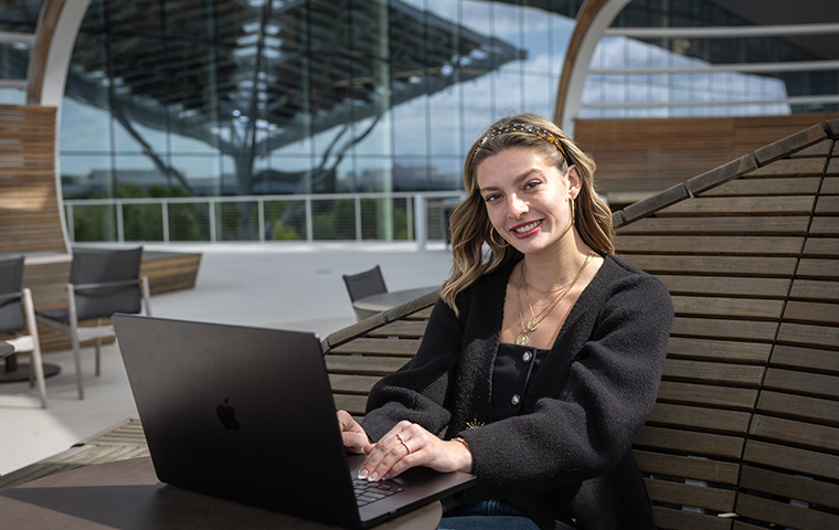 Ally Flinn on laptop outside Nvidia Headquarters