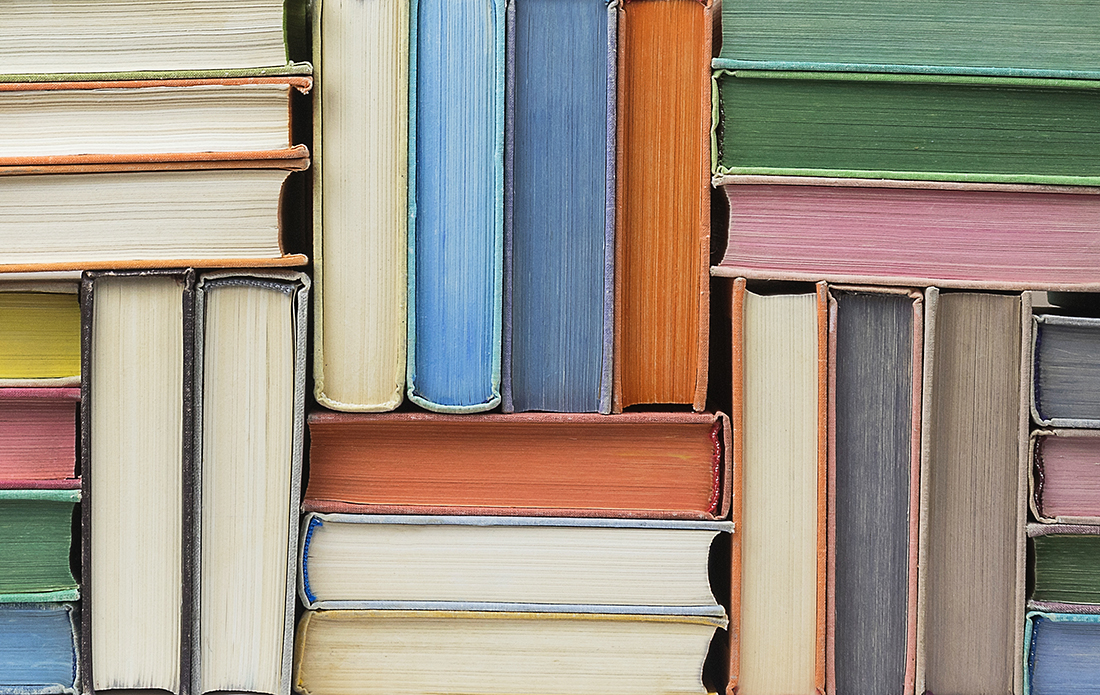 Books stacked and arranged into a multi-colored wall