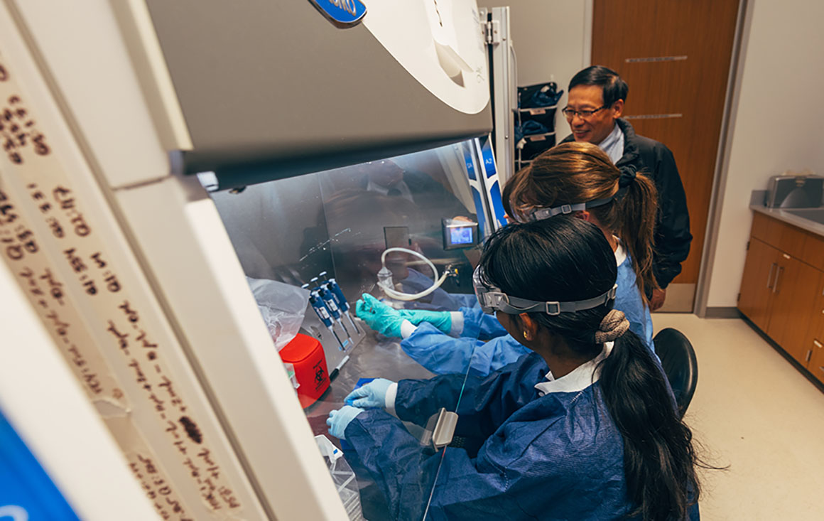 professor works with two students in the lab