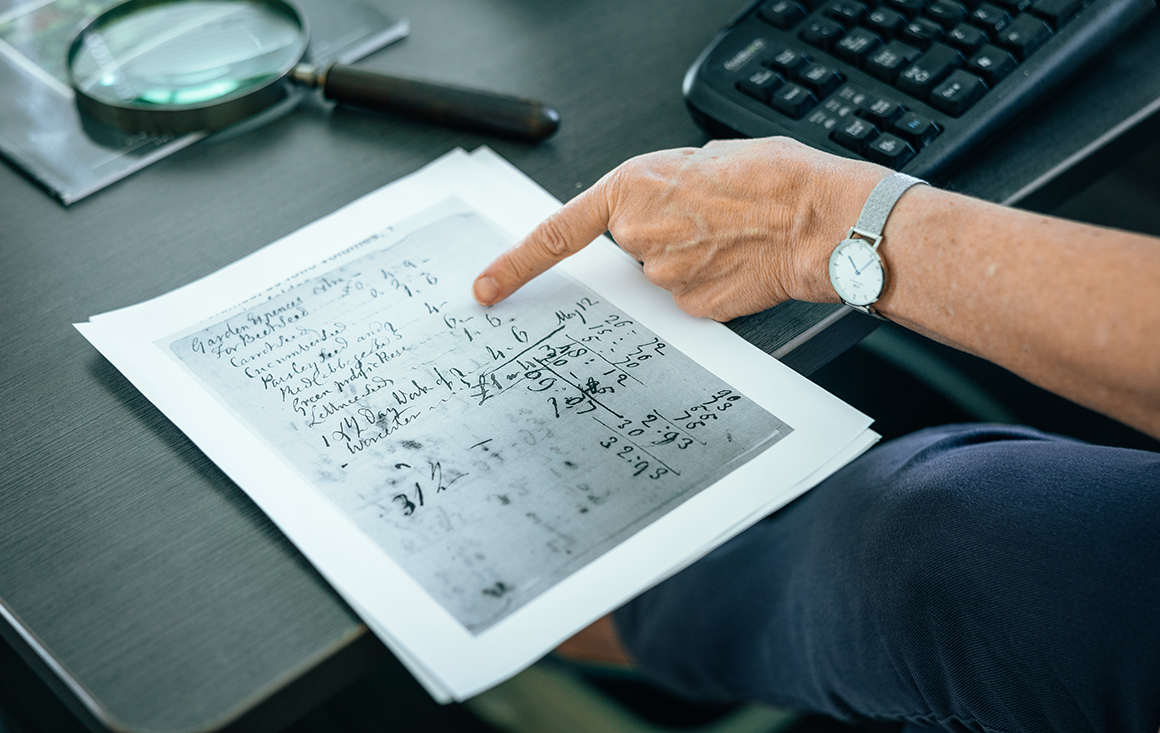 A woman points to a line item on a hand-written receipt.