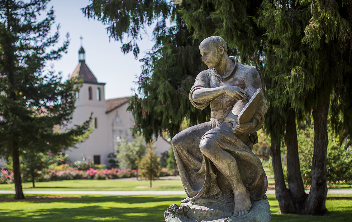 St Ignatius Statue on Santa Clara's campus with Mission Church in background.