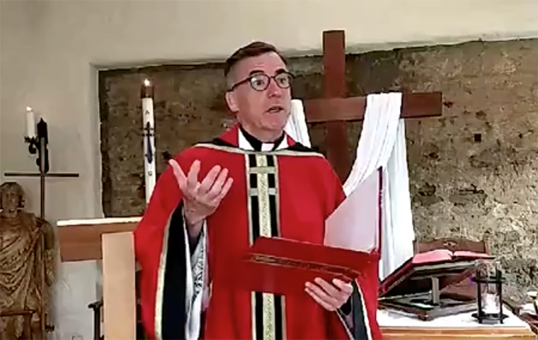 Kevin O'Brien, S.J., standing in the St. Francis Chapel