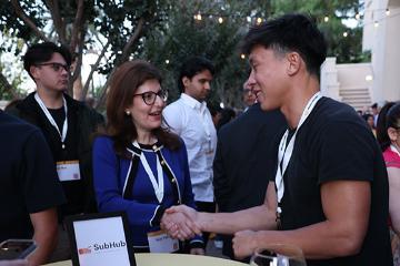 Subhub team talking to a woman at Demo Day 2025