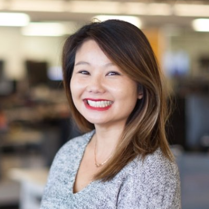 A woman smiling in an office environment.