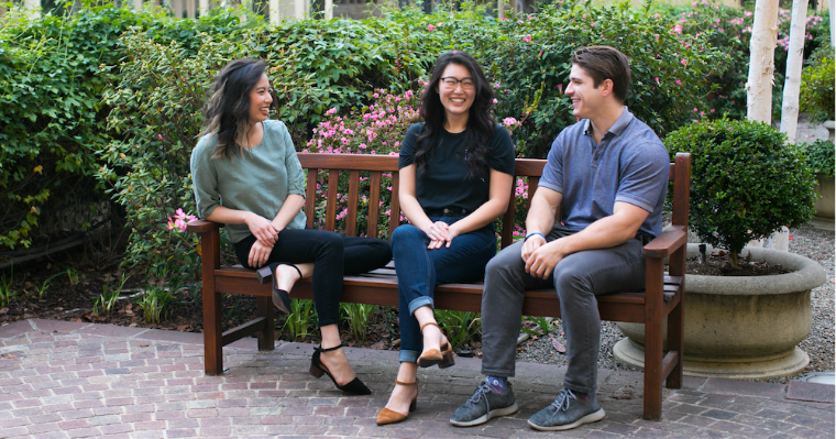 Garrett Jensen and two others sitting on a bench outdoors