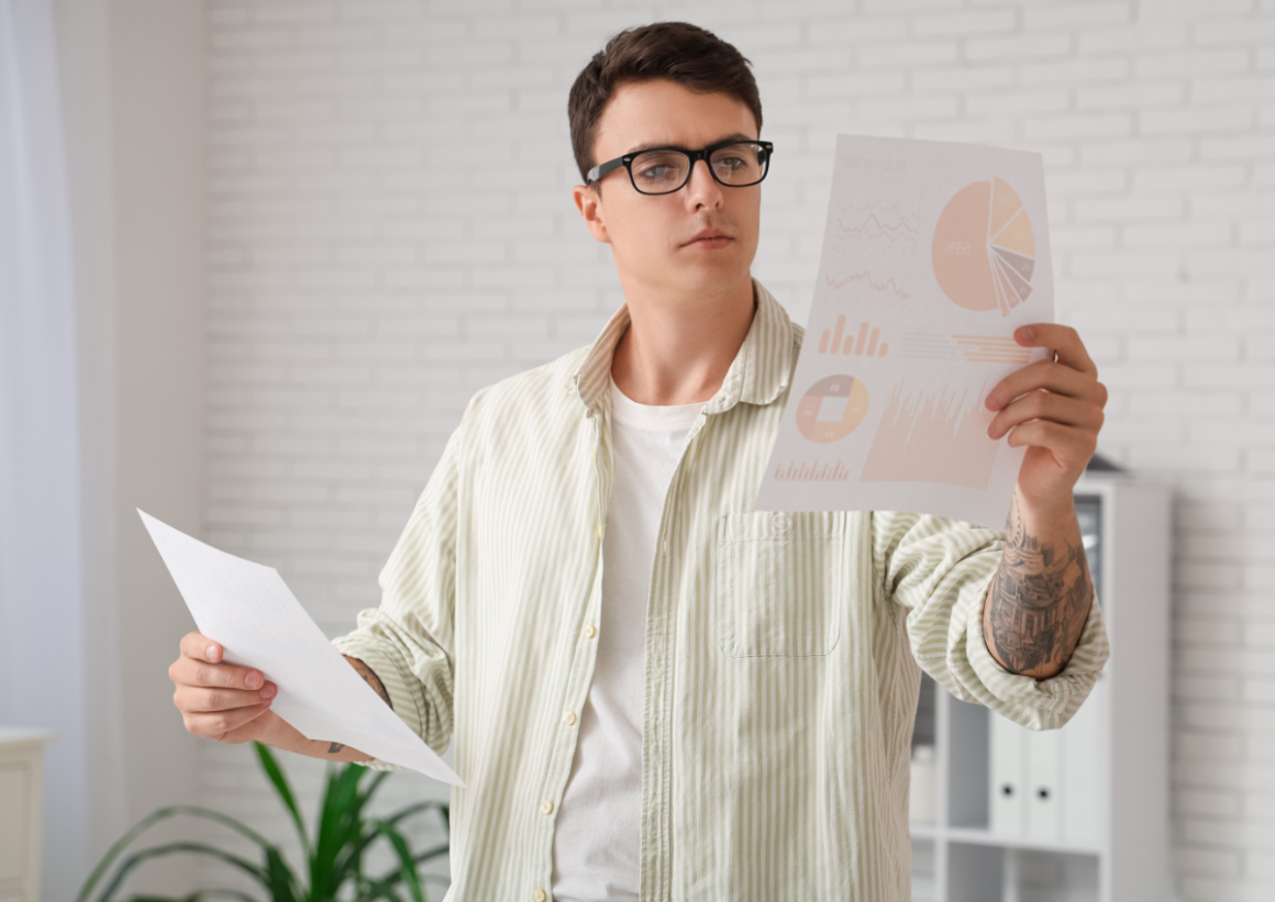 Man in glasses studying paper charts