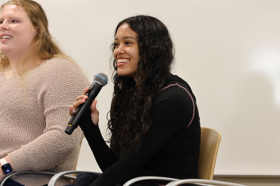 Undergraduate business student and athlete on the women's basketball team smiling with microphone