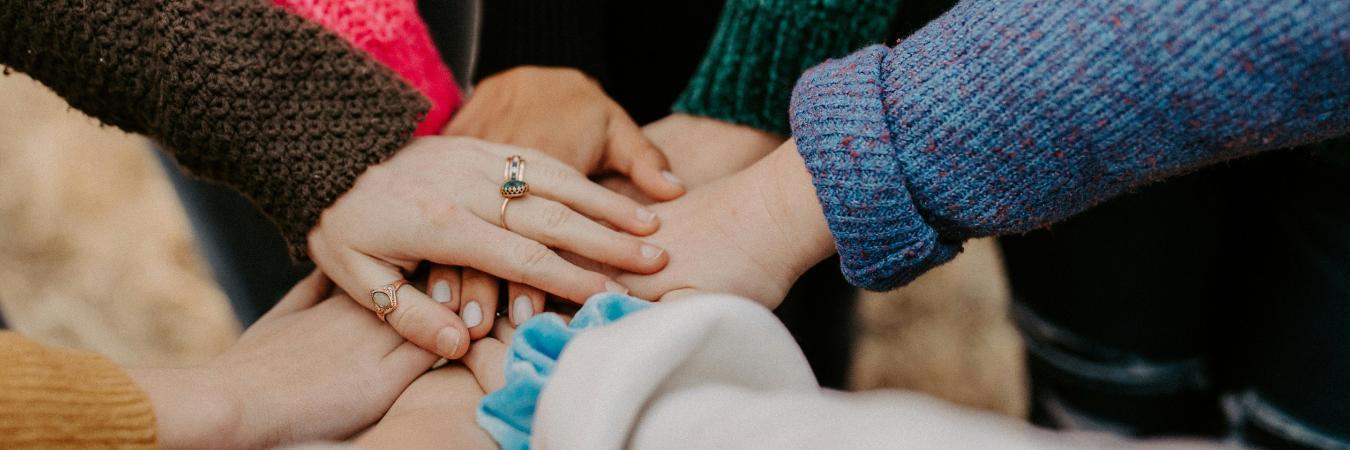 Hands piled together indicating corporate teamwork