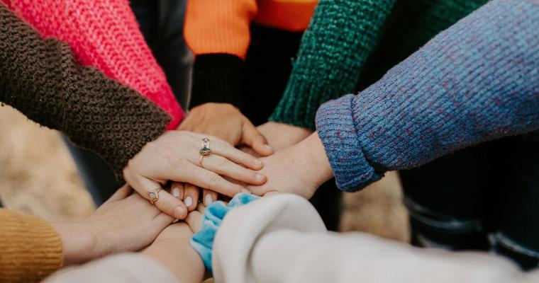 Hands piled together indicating corporate teamwork