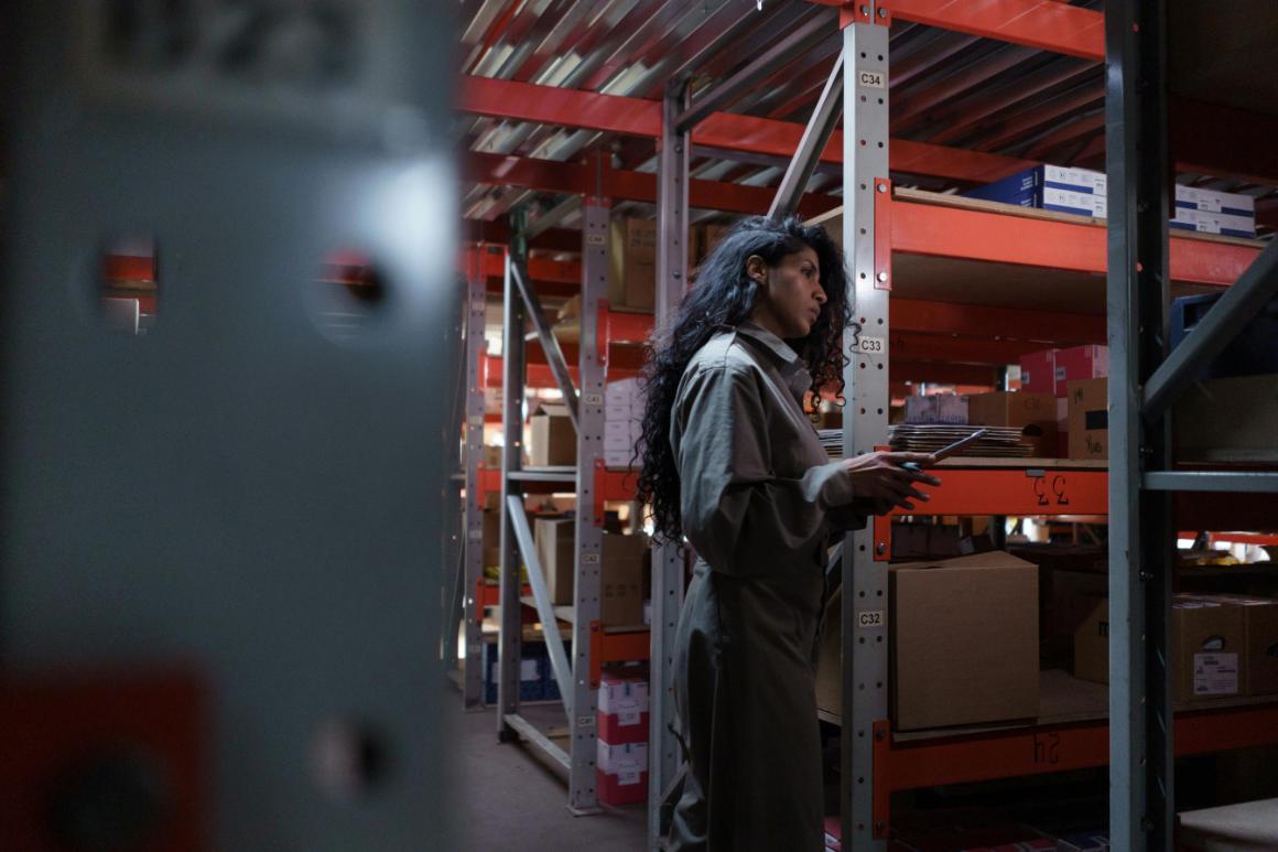 Night shift employee completing warehouse inventory on a tablet
